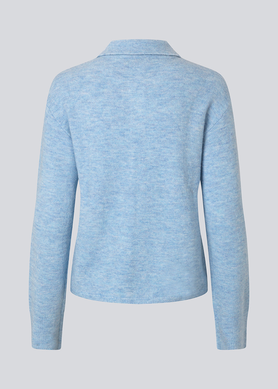 Strikket polo i blå med lange brede ærmer. Treemd polo har en stolpelukning og 4 knapper. Modellen er 175 cm og har en str. S/36 på.