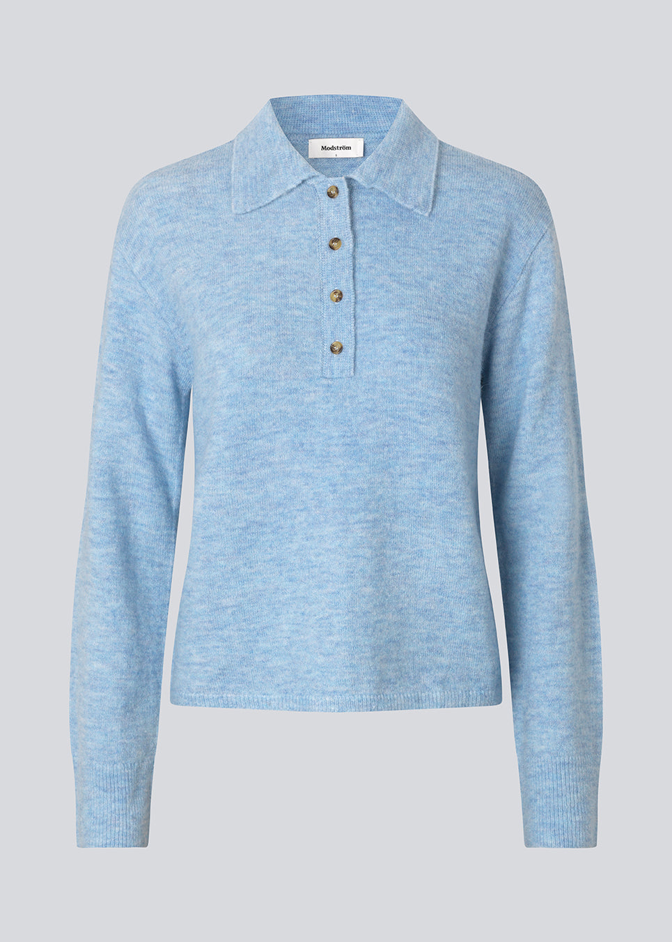 Strikket polo i blå med lange brede ærmer. Treemd polo har en stolpelukning og 4 knapper. Modellen er 175 cm og har en str. S/36 på.