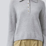 Strikket polo i grå med lange brede ærmer. Treemd polo har en stolpelukning og 4 knapper. Modellen er 175 cm og har en str. S/36 på.