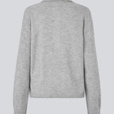Strikket polo i grå med lange brede ærmer. Treemd polo har en stolpelukning og 4 knapper. Modellen er 175 cm og har en str. S/36 på.
