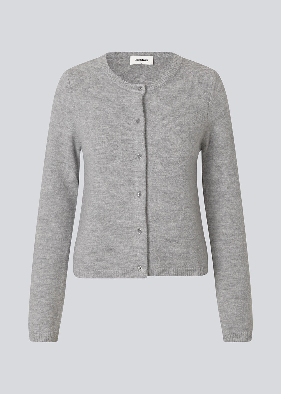 Lysegrå tætsiddende cardigan i blød strik. TreeMD cardigan har en rund hals og fine knapper i matchende farve, der understreger det enkle og feminine udtryk.
