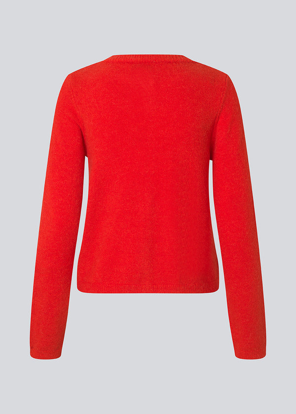 Rød tætsiddende cardigan i blød strik. TreeMD cardigan har en rund hals og fine knapper i matchende farve, der understreger det enkle og feminine udtryk.