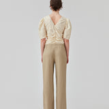 Lange bukser i farven Dune i et relaxed fit med lange brede ben, og elastik i taljen for ekstra komfort. TulsiMD pants er lavet i en blød blanding af hør og rayon. Modellen er 177 cm og har en størrelse S/36 på.