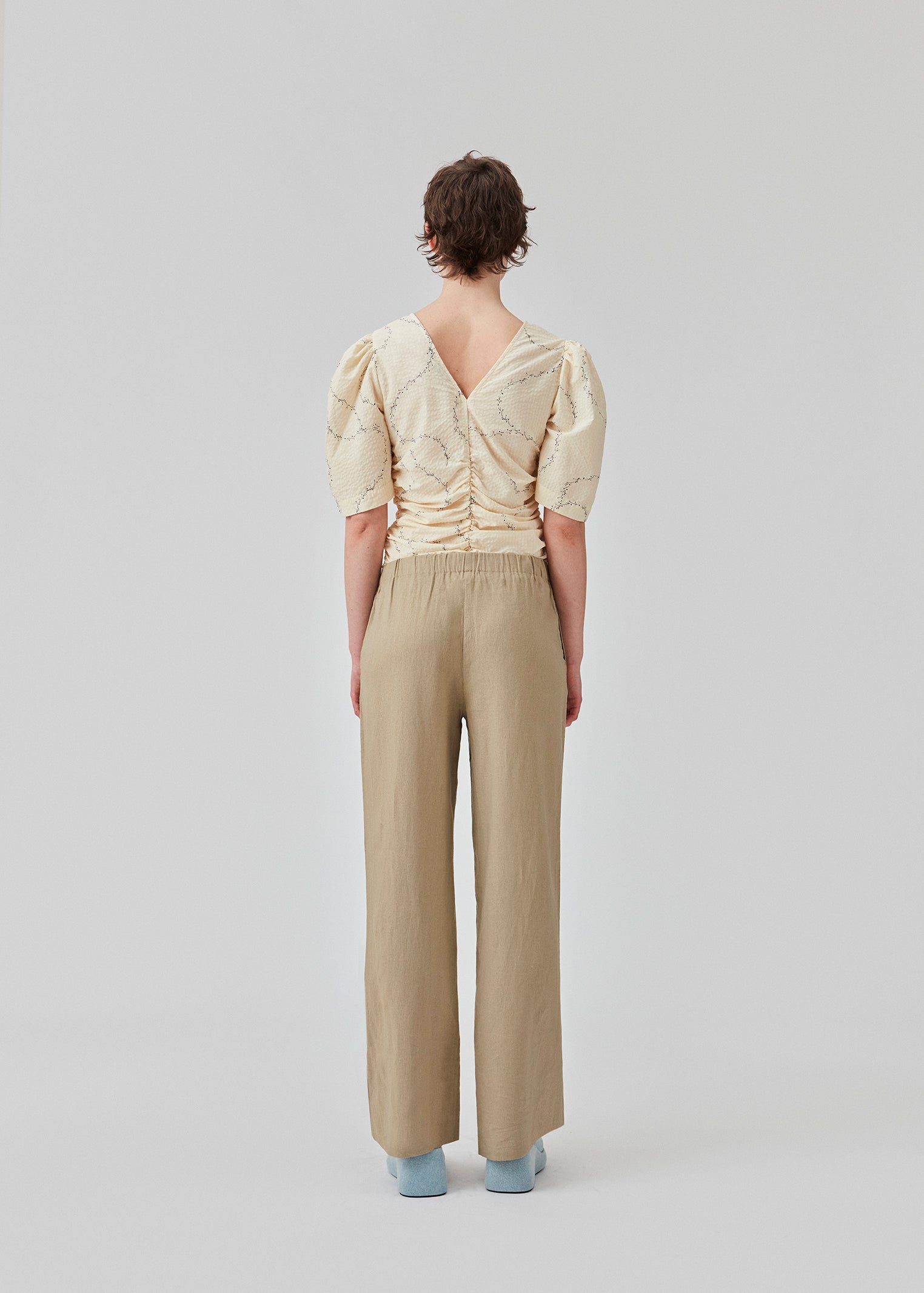 Lange bukser i farven Dune i et relaxed fit med lange brede ben, og elastik i taljen for ekstra komfort. TulsiMD pants er lavet i en blød blanding af hør og rayon. Modellen er 177 cm og har en størrelse S/36 på.