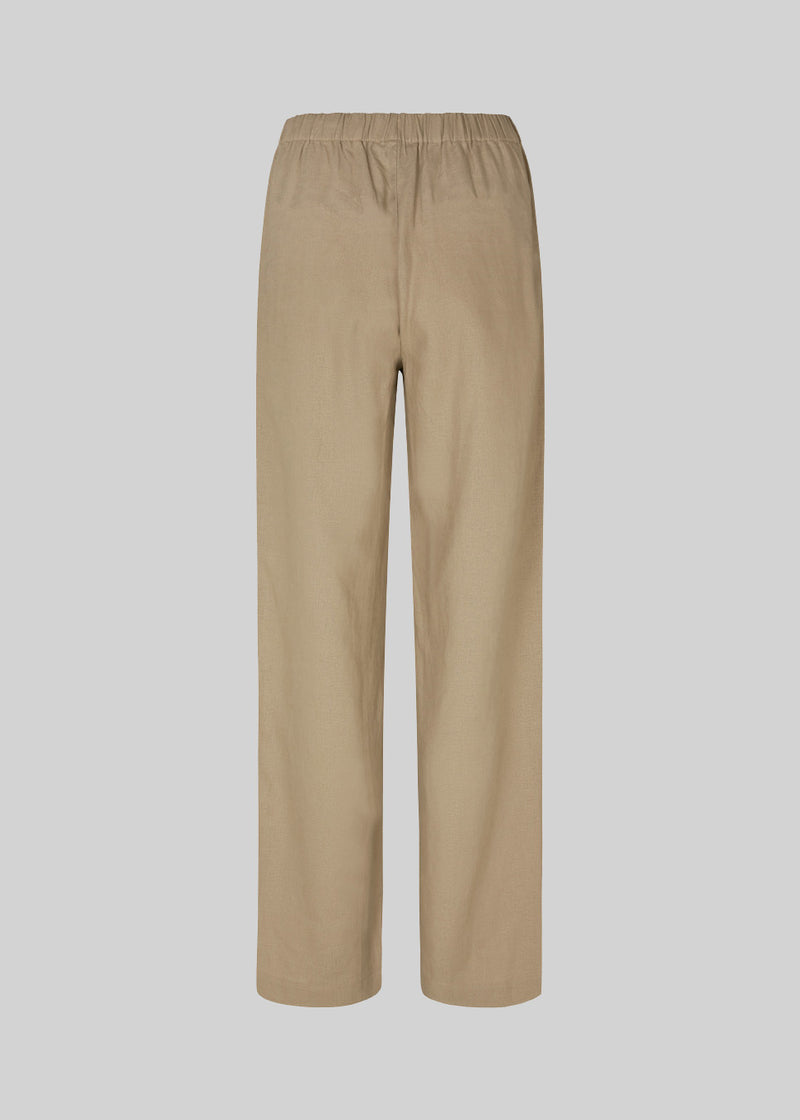 Lange bukser i farven Dune i et relaxed fit med lange brede ben, og elastik i taljen for ekstra komfort. TulsiMD pants er lavet i en blød blanding af hør og rayon. Modellen er 177 cm og har en størrelse S/36 på.