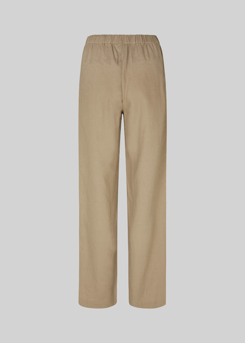 Lange bukser i farven Dune i et relaxed fit med lange brede ben, og elastik i taljen for ekstra komfort. TulsiMD pants er lavet i en blød blanding af hør og rayon. Modellen er 177 cm og har en størrelse S/36 på.