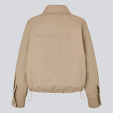 Kort beige jakke i trenchcoat look. Umamd jacket har skjortekrave, sidelommer, knappelukning og justerbar elastik i bunden. Modellen er 175 cm og har en str. S/36 på.

Materiale:
97% Bomuld
3% Elastan

Foer:
100% Polyester