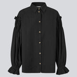 Feminin skjorte i sort med smock og flæsedetaljer. Ulfurmd shirt har ensfarvede striber, krave, knappelukning og volumøse ærmer med smock og flæser – en elegant og moderne skjorte, der giver et sofistikeret touch til hverdags- og arbejdslooks. Modellen er 175 cm og har en str. S/36 på.


Materiale:
40% Bomuld
60% Recycled Polyester