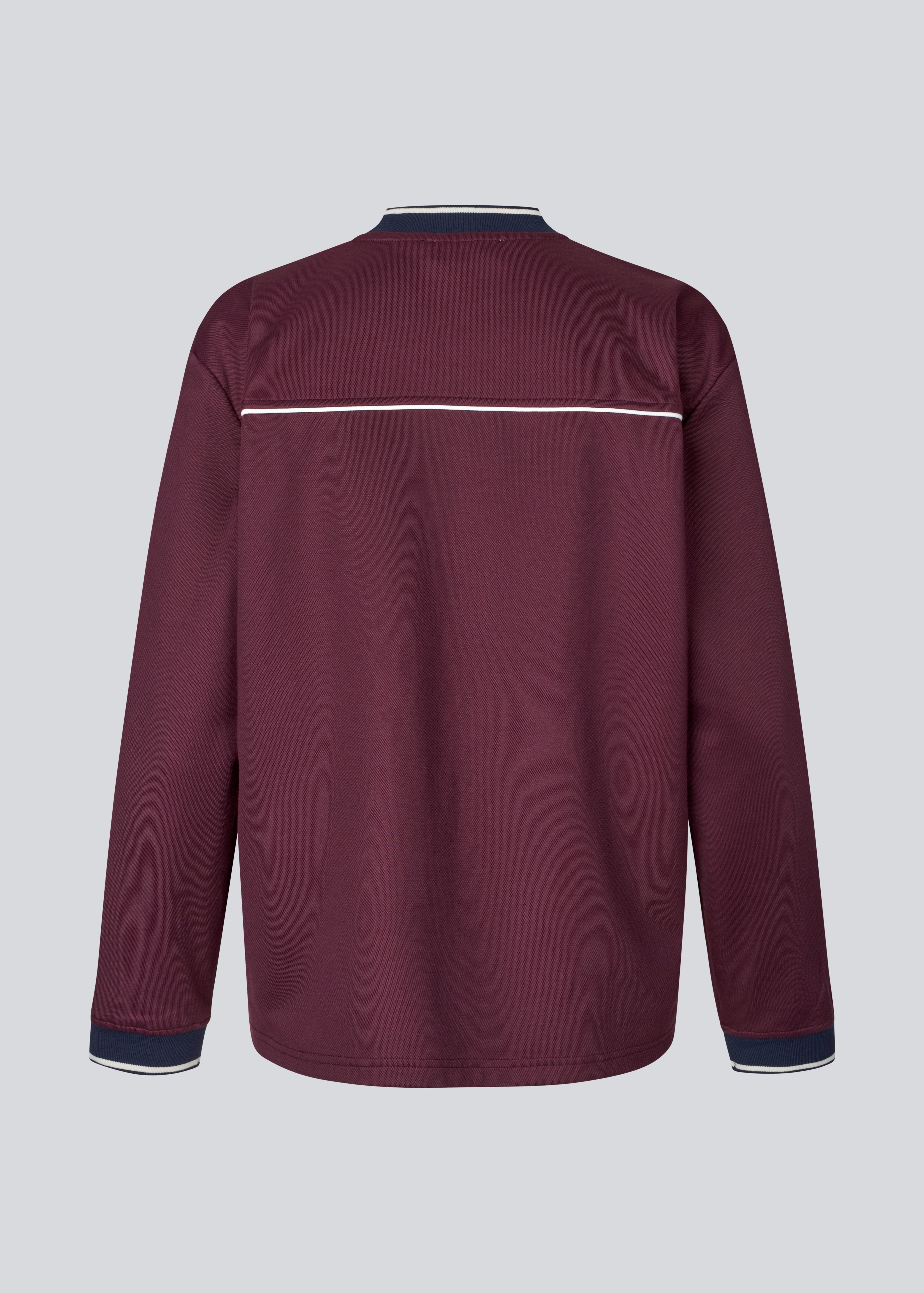 Mørkerød tracksuit trøje i 100% genanvendt polyester. Utopiamd LS t-shirt har lange ærmer, v-hals med kontrastdetaljer samt logo foran.