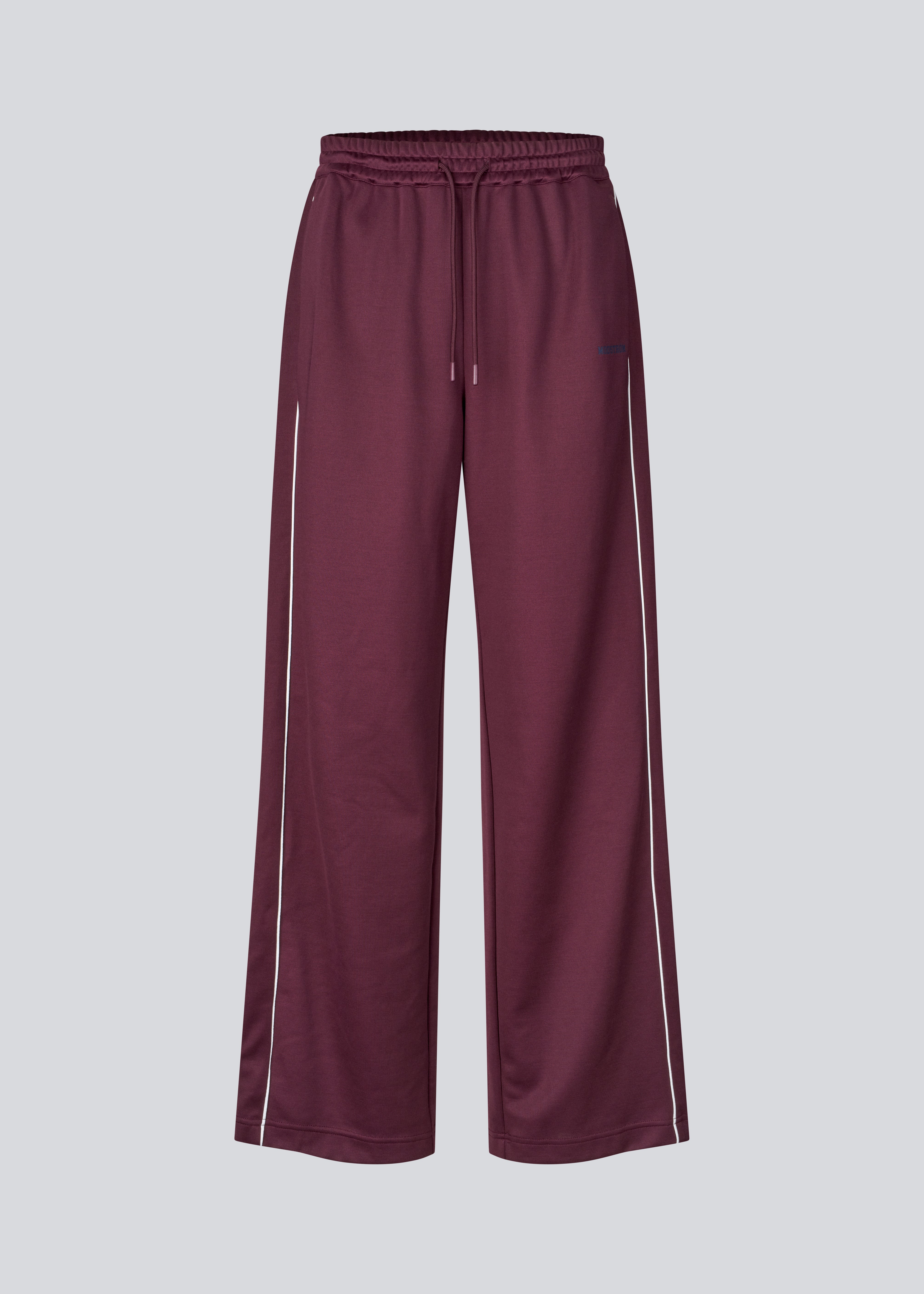 Mørkerøde tracksuit pants med brede ben i 100% genanvendt polyester. Utopiamd pants har sidelommer, elastik i talje med snørre og logo.