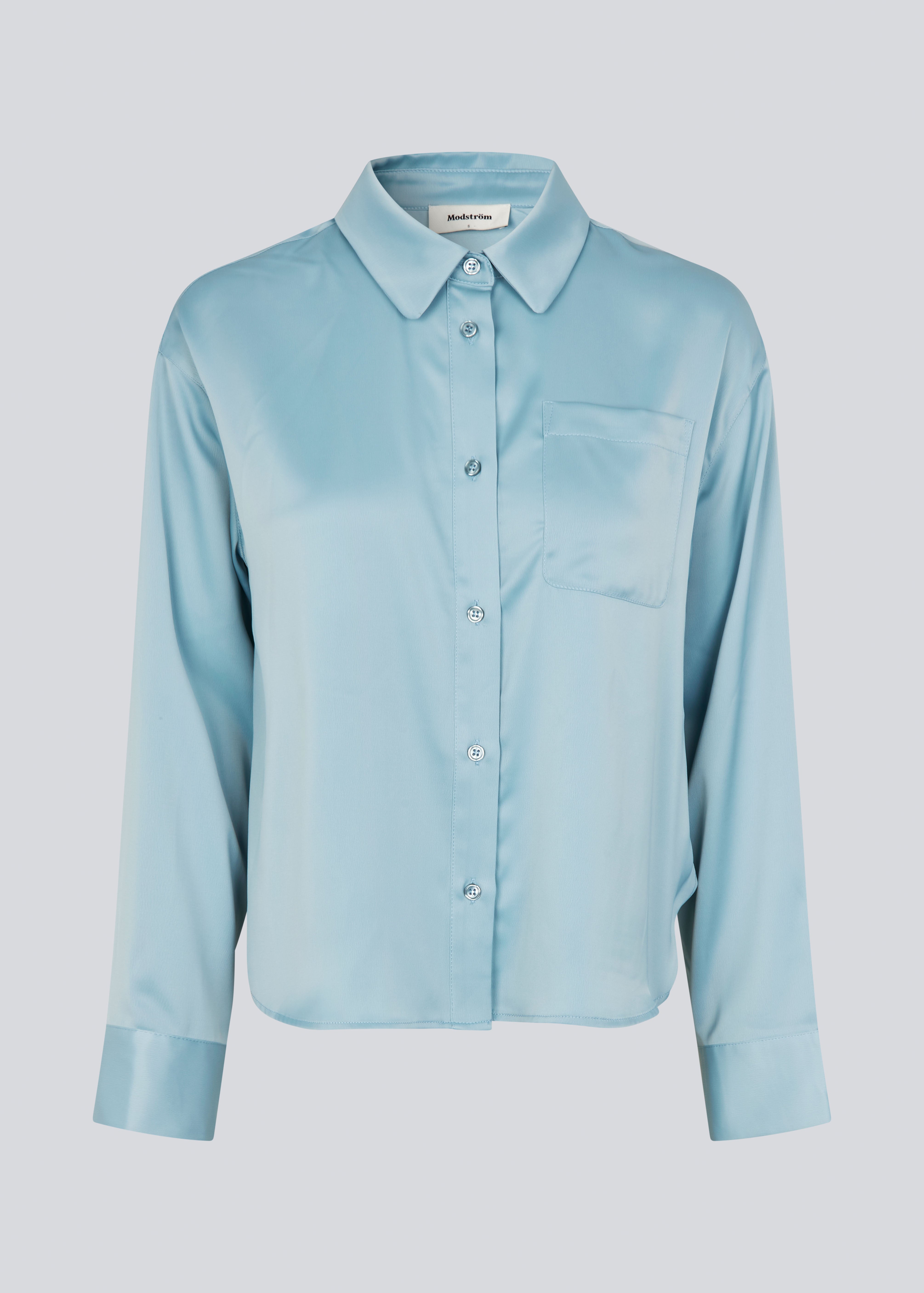 Feminin skjorte i glansfuld satin. Valdomd shirt har klassiske detaljer som brystlomme, lange ærmer, knappelukning og går til buksekanten. Fremstillet i 98% genanvendt polyester - skjorten er perfekt til både elegante og casual looks.
