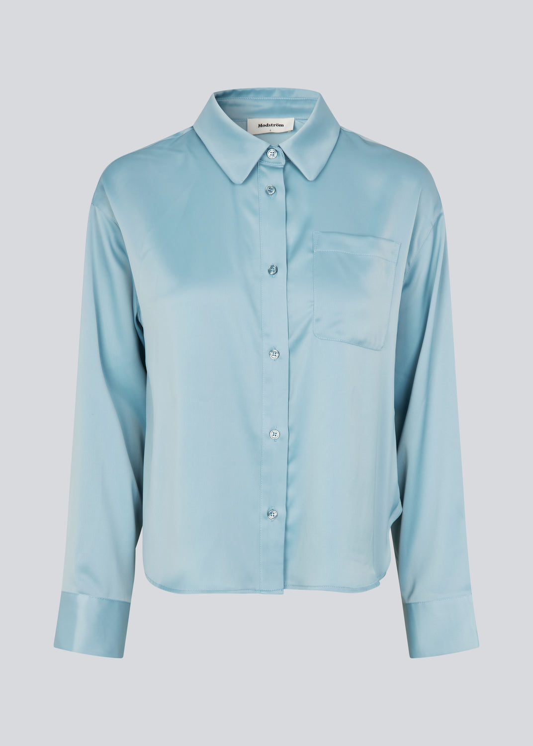 Feminin skjorte i glansfuld satin. Valdomd shirt har klassiske detaljer som brystlomme, lange ærmer, knappelukning og går til buksekanten. Fremstillet i 98% genanvendt polyester - skjorten er perfekt til både elegante og casual looks.