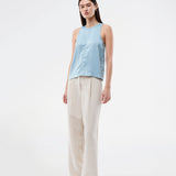 Ærmeløs blå top i glansfuld satin. Valdomd Top har rund halsudskæring, lodret sygningsdetalje foran og knappelukning i nakken for et elegant look. Fremstillet i 98 % genanvendt polyester.&nbsp;
