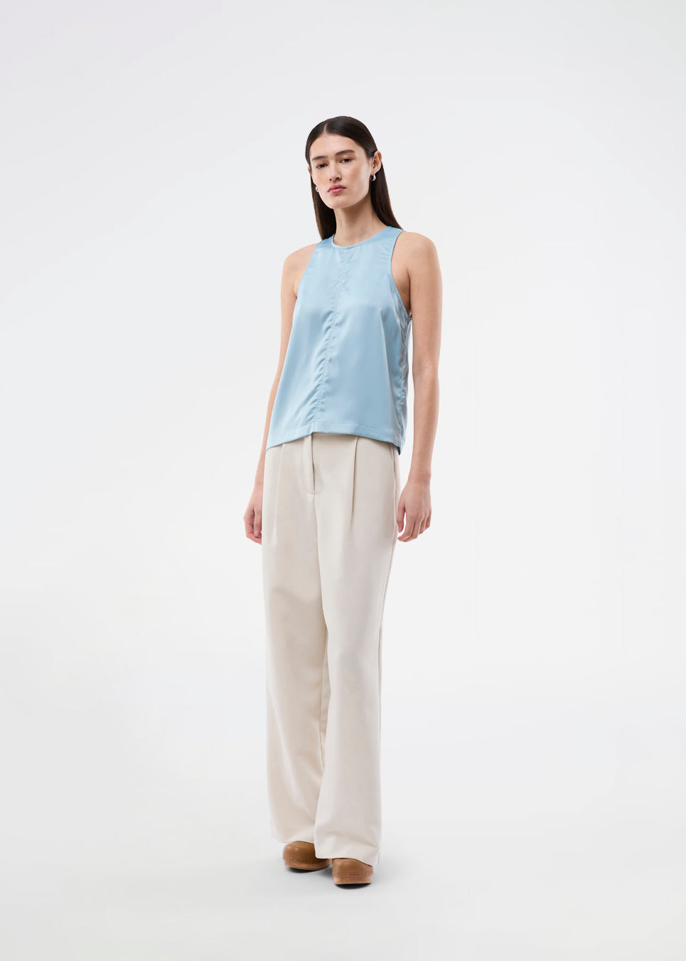 Ærmeløs blå top i glansfuld satin. Valdomd Top har rund halsudskæring, lodret sygningsdetalje foran og knappelukning i nakken for et elegant look. Fremstillet i 98 % genanvendt polyester.&nbsp;