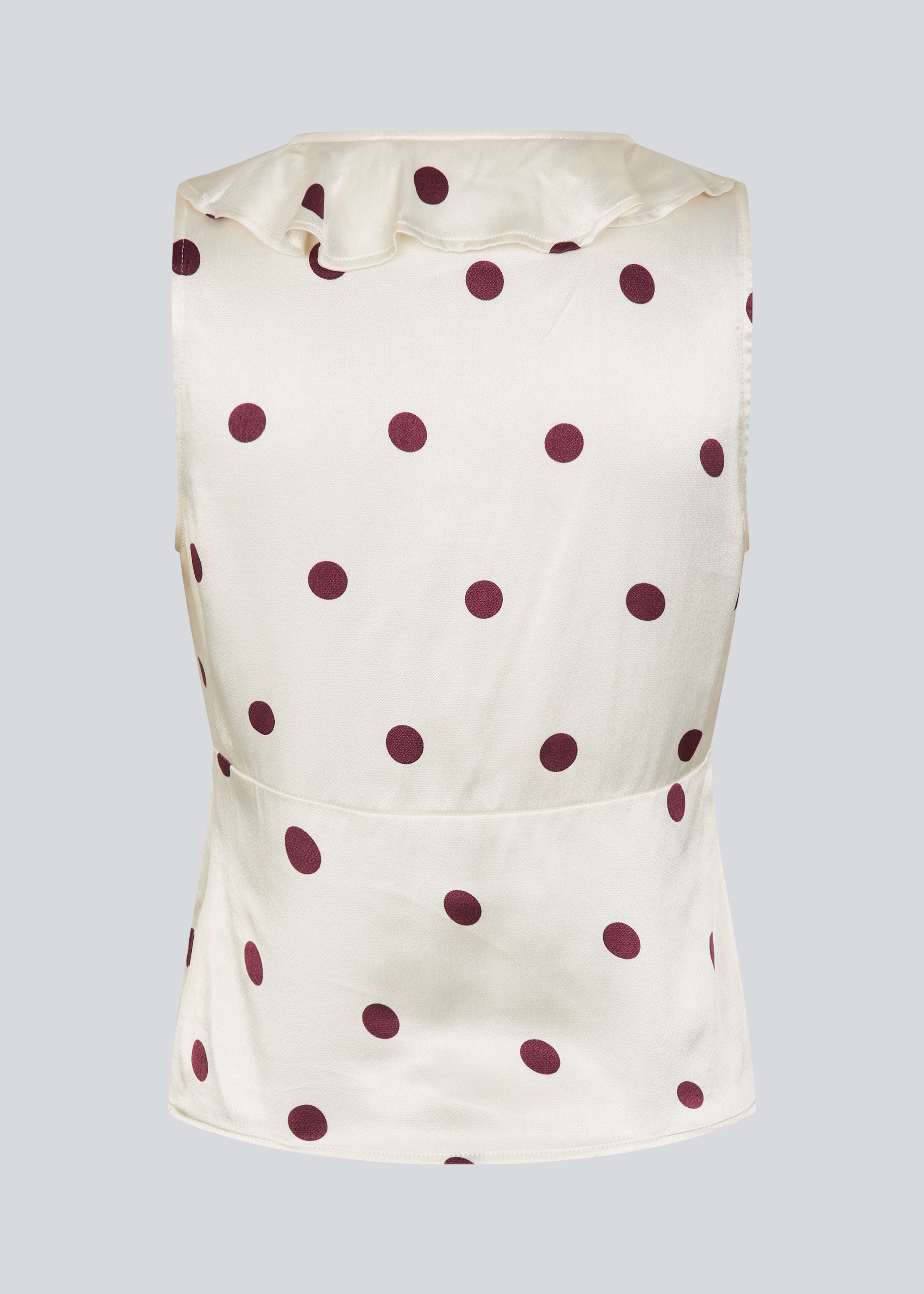 Ærmeløs top med polkaprikker og flæsekant. Vanjamd Print Top har femine detaljer som v-udskæring, rynkekant og bindedetalje under barmen for et elegant look.&nbsp;