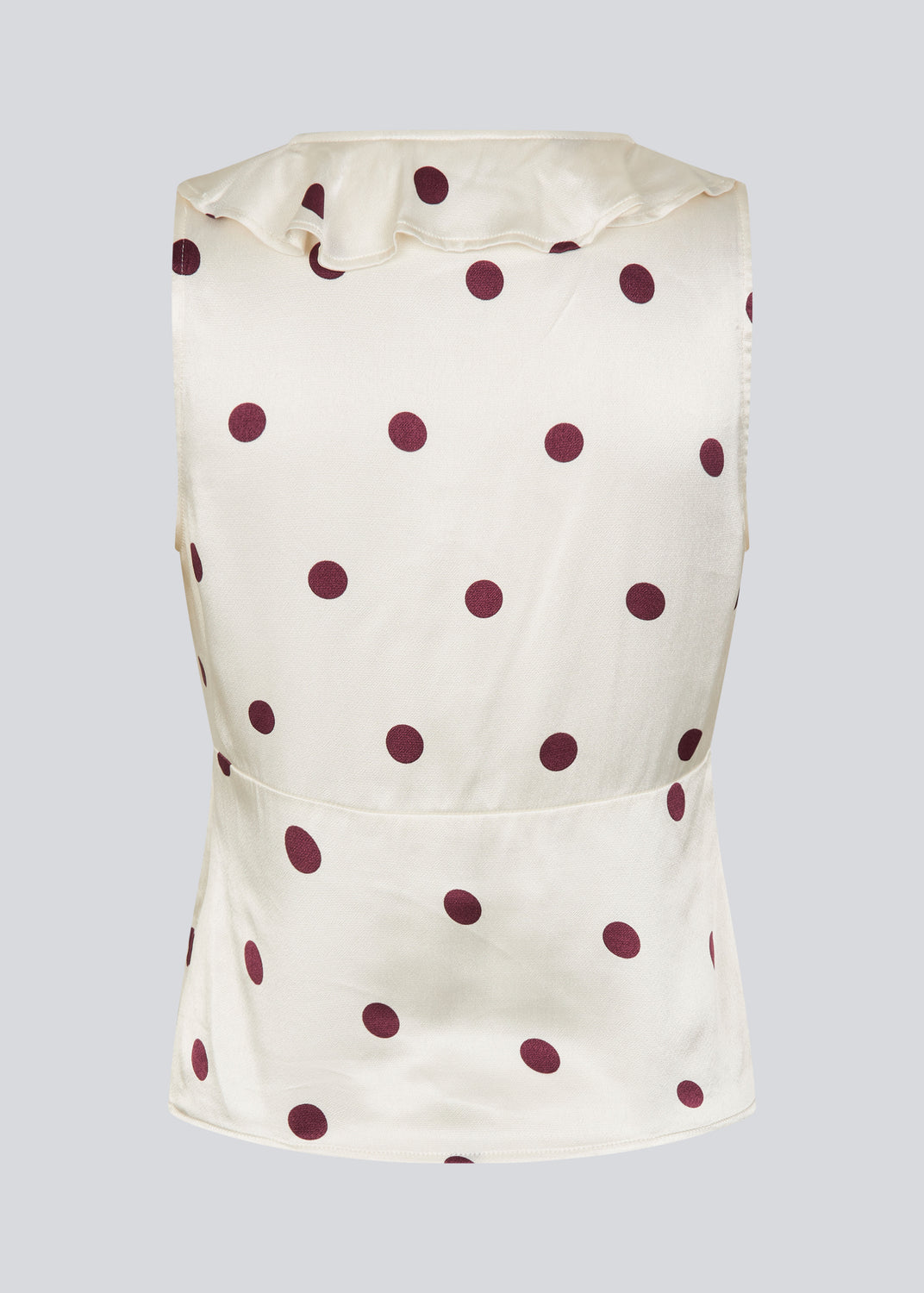 Ærmeløs top med polkaprikker og flæsekant. Vanjamd Print Top har femine detaljer som v-udskæring, rynkekant og bindedetalje under barmen for et elegant look.&nbsp;