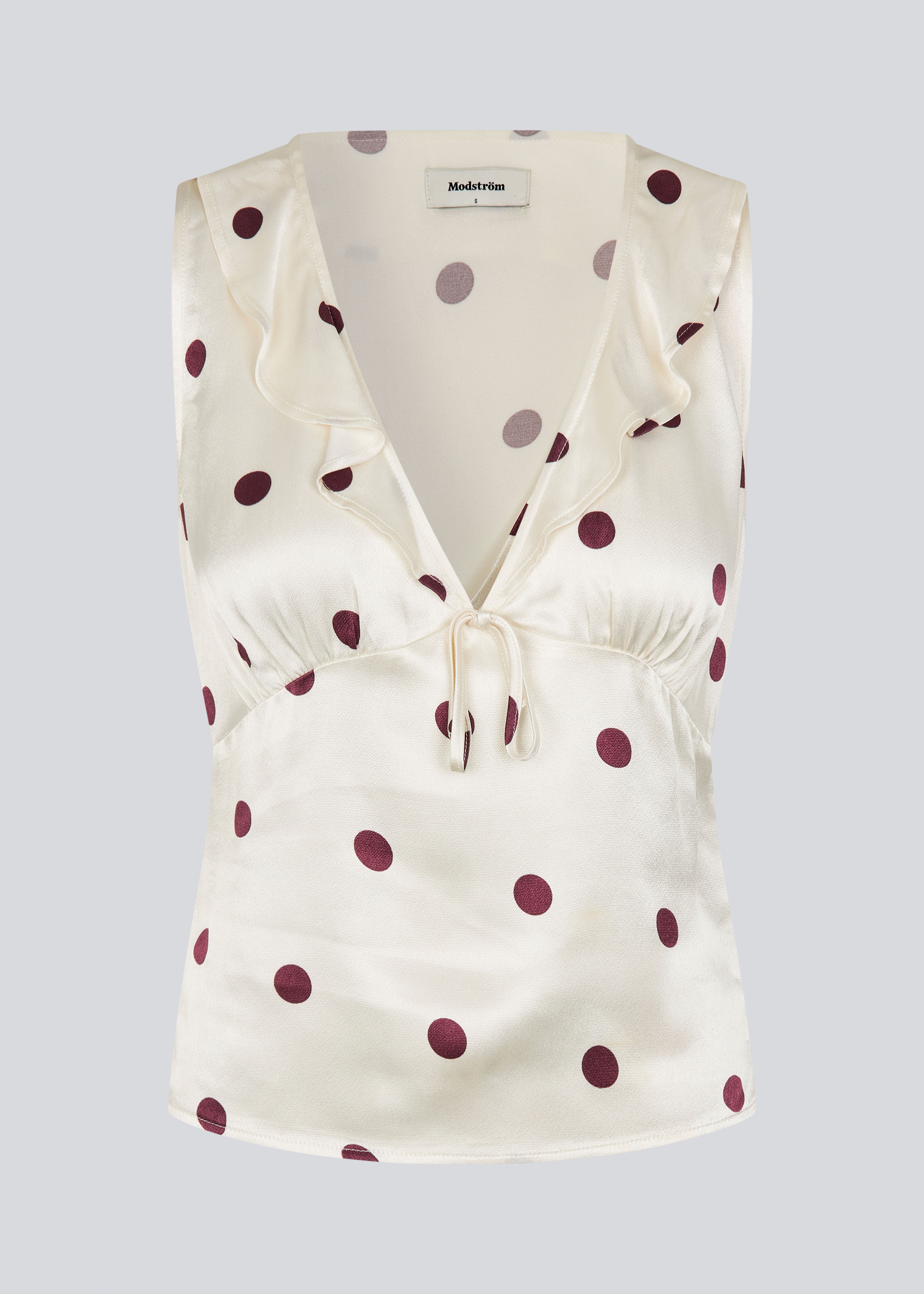 Ærmeløs top med polkaprikker og flæsekant. Vanjamd Print Top har femine detaljer som v-udskæring, rynkekant og bindedetalje under barmen for et elegant look.&nbsp;