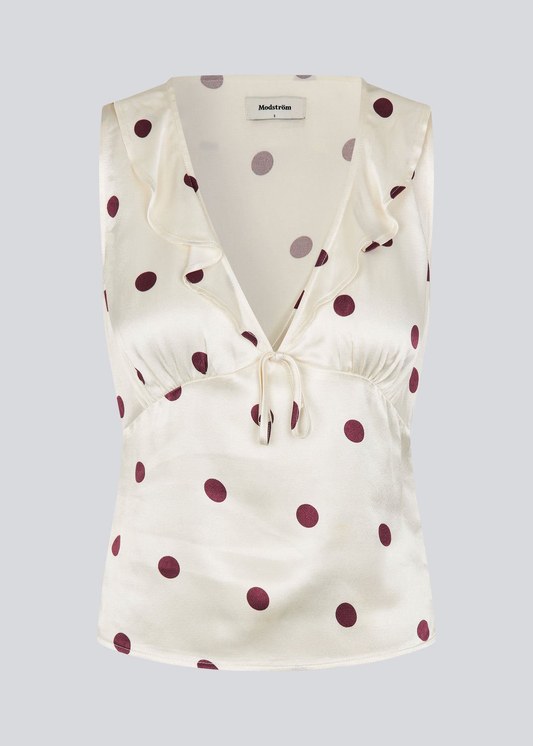 Ærmeløs top med polkaprikker og flæsekant. Vanjamd Print Top har femine detaljer som v-udskæring, rynkekant og bindedetalje under barmen for et elegant look.&nbsp;