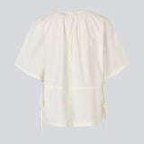 Let og feminin top i hvid. Vilbertmd top er designet med bløde læg ved halsen, korte vide ærmer og bindebånd i siden, der skaber et afslappet men raffineret udtryk. En elegant style, der nemt kan dresses op eller ned i den moderne garderobe.