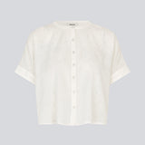 Kortærmet skjorte-bluse i hvid med ensfarvet print. VilleminMD shirt har knappelukning, rund halsudskæring og opsmøg på ærmerne, og længden går til buksekanten. Et tidløst og elegant valg, der nemt kan styles både til hverdag og aften.