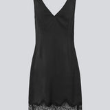 Kort sort satinkjole med blonde detaljer i bunden og over brystet. Vuemd Dress har brede stropper, krydsdetalje med blonder over brystet og en skjult lynlås i siden. En elegant og feminin style, der er perfekt til både hverdag og fest.