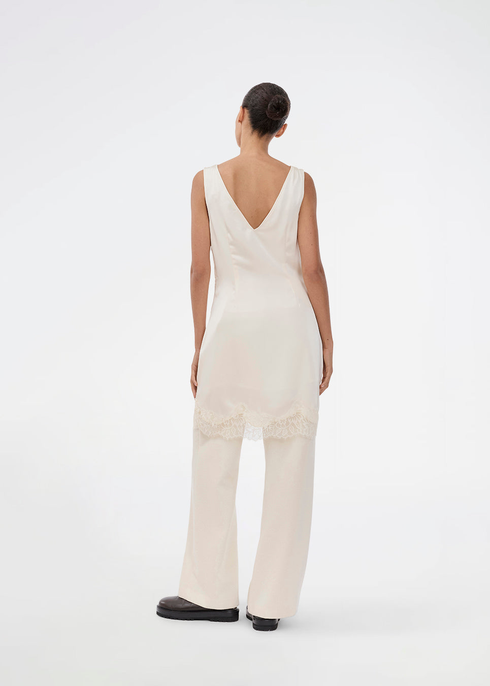 Kort hvid satin kjole med blonde detaljer. Vuemd Dress har brede stropper, krydsdetalje over brystet og en skjult lynlås i siden. En elegant og feminin style, der er perfekt til både hverdag og fest.