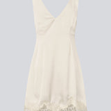 Kort hvid satin kjole med blonde detaljer. Vuemd Dress har brede stropper, krydsdetalje over brystet og en skjult lynlås i siden. En elegant og feminin style, der er perfekt til både hverdag og fest.