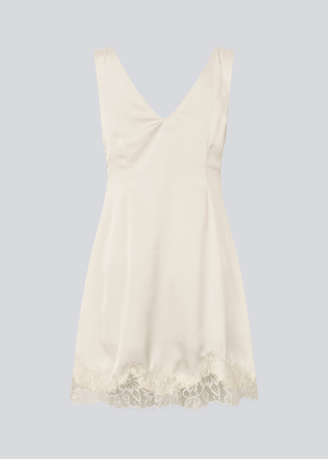 Kort hvid satin kjole med blonde detaljer. Vuemd Dress har brede stropper, krydsdetalje over brystet og en skjult lynlås i siden. En elegant og feminin style, der er perfekt til både hverdag og fest.