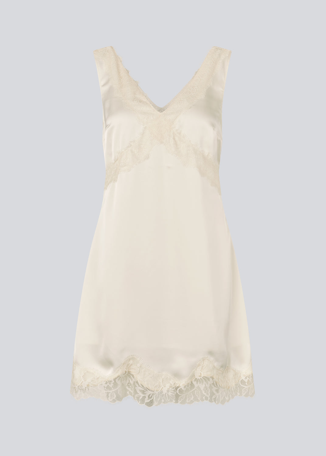 Kort hvid satin kjole med blonde detaljer. Vuemd Dress har brede stropper, krydsdetalje over brystet og en skjult lynlås i siden. En elegant og feminin style, der er perfekt til både hverdag og fest.