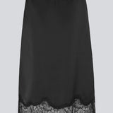 Sort satin nederdel med blondedetaljer i bunden. Vuemd skirt er knælang med eleastik i taljen og har en afslappet pasform. Ideel alene eller stylet som en del af en lag-på-lag styling.