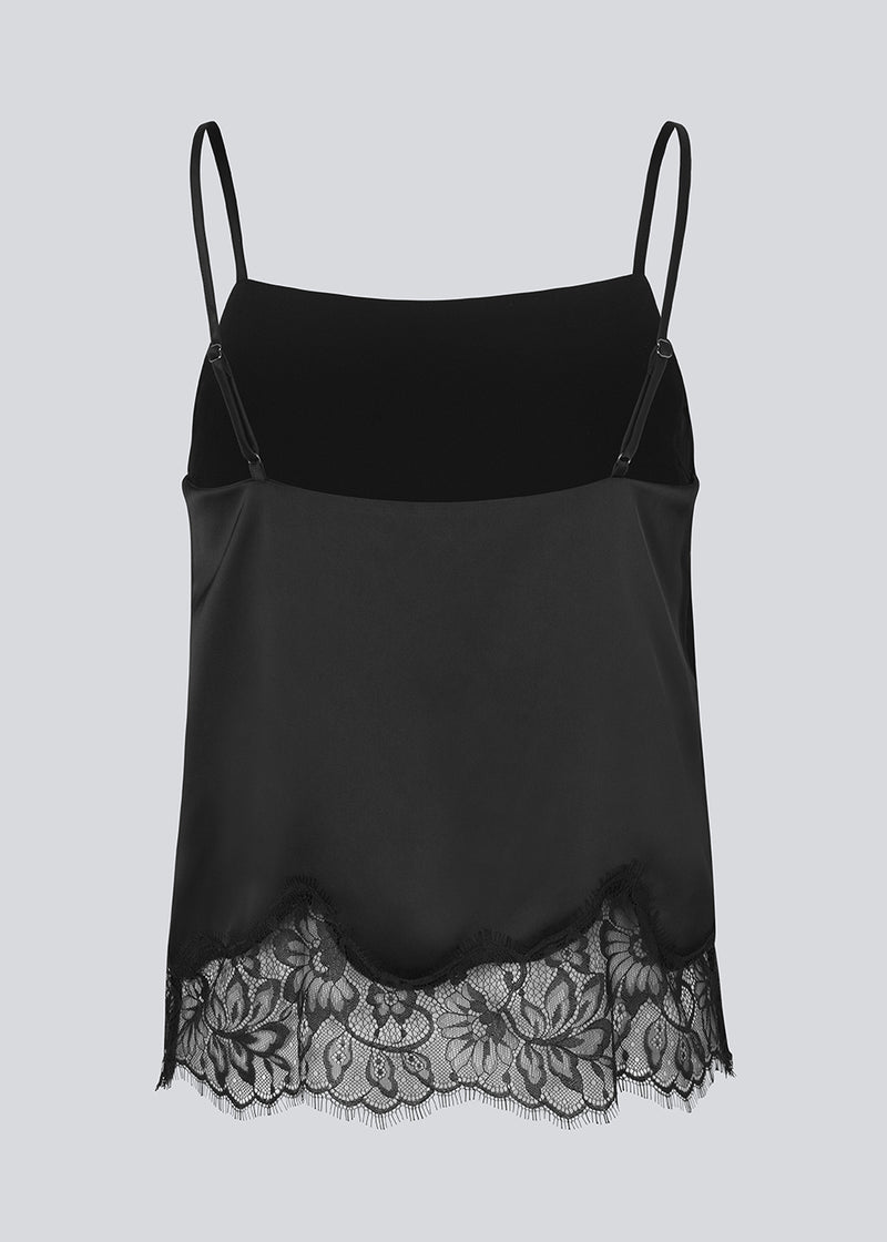 Elegant sort top i satin med blondekant i buden. Vuemd top har justerbare stropper og fine blondedetaljer i bunden. Ideel alene eller stylet som en del af en lag-på-lag styling.