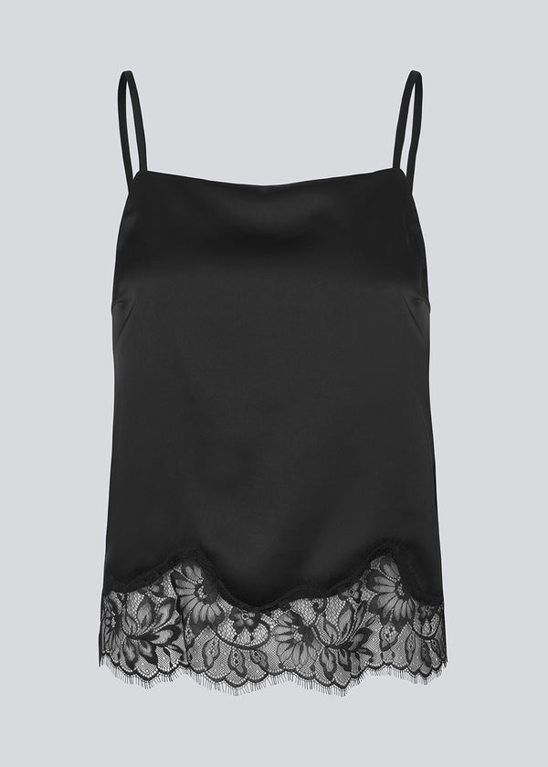 Elegant sort top i satin med blondekant i buden. Vuemd top har justerbare stropper og fine blondedetaljer i bunden. Ideel alene eller stylet som en del af en lag-på-lag styling.