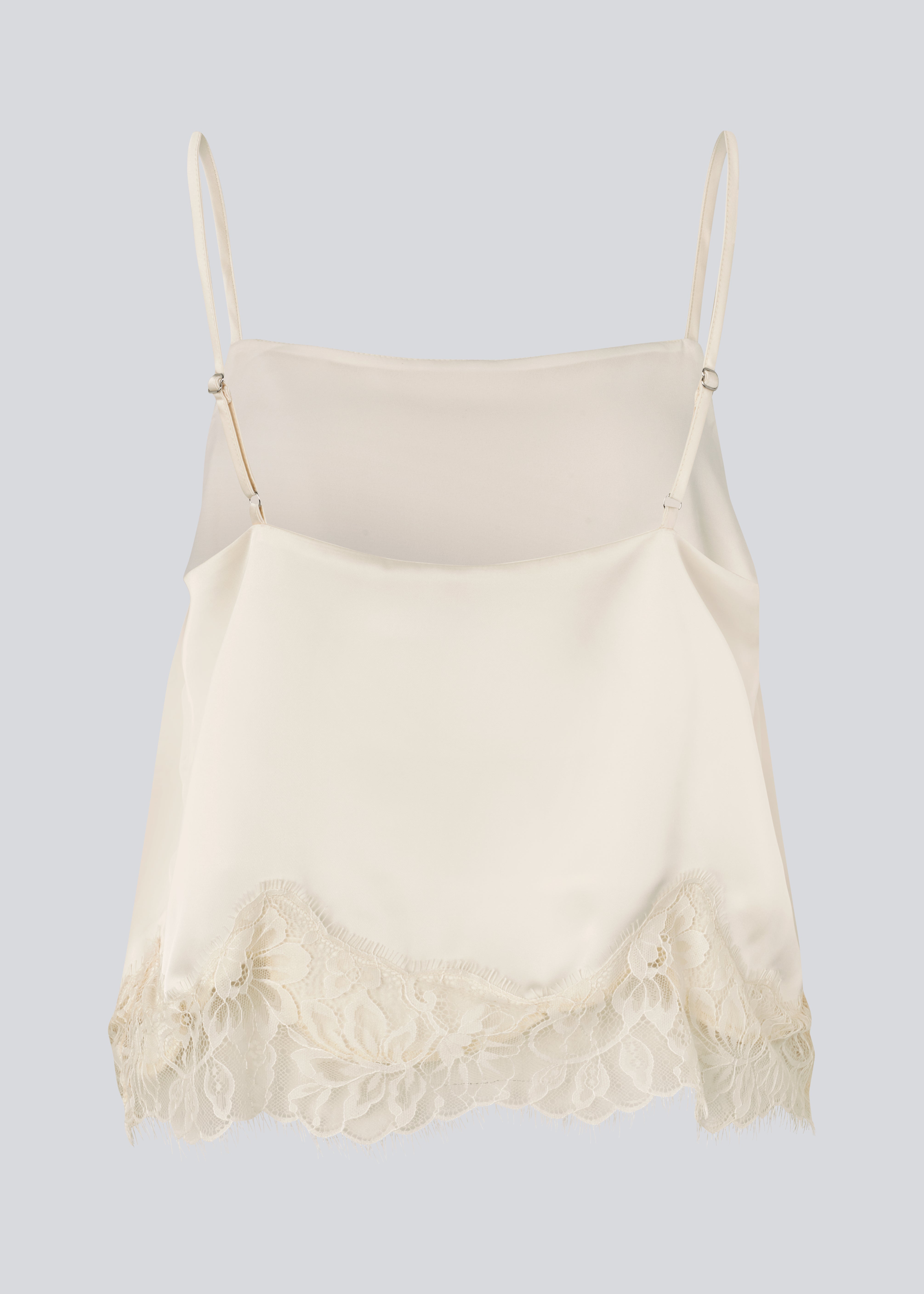Delikat hvid top i satin. Vuemd top har justerbare stropper og fine blondedetaljer i bunden. Ideel alene eller stylet som en del af en lag-på-lag styling.
