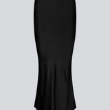 Sort lang nederdel med vidde i satin. Parveenmd skirt har en elastik i taljen. Modellen er 175 cm og har en str. s/36 på.