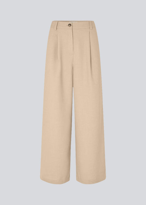 Lyse bukser med afslappet pasform. GaleMD 2 wide pants har almindelig talje med læg foran og brede, lange ben. Dekorative paspolerede lommer bagpå og sidelommer.

Opgrader din garderobe med GaleMD 2 Wide Pants fra Modström – en perfekt kombination af stil og komfort. Disse bukser i beige melange, har en løs pasform, høj talje og læg, der giver et elegant og flatterende look. Den fine basis farve, beige, gør dem lette at style til enhver anledning – fra afslappede hverdage til mere formelle outfits.