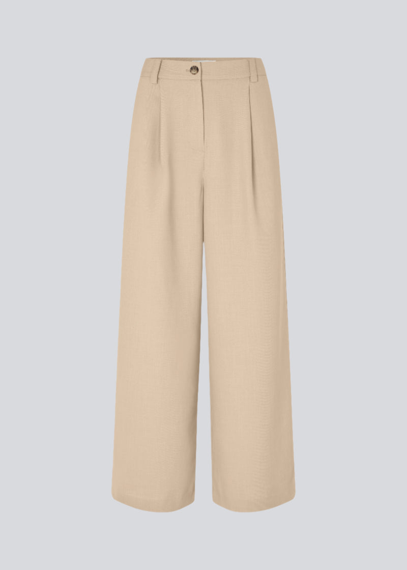 Lyse bukser med afslappet pasform. GaleMD 2 wide pants har almindelig talje med læg foran og brede, lange ben. Dekorative paspolerede lommer bagpå og sidelommer.

Opgrader din garderobe med GaleMD 2 Wide Pants fra Modström – en perfekt kombination af stil og komfort. Disse bukser i beige melange, har en løs pasform, høj talje og læg, der giver et elegant og flatterende look. Den fine basis farve, beige, gør dem lette at style til enhver anledning – fra afslappede hverdage til mere formelle outfits.