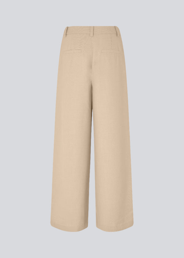 Lyse bukser med afslappet pasform. GaleMD 2 wide pants har almindelig talje med læg foran og brede, lange ben. Dekorative paspolerede lommer bagpå og sidelommer.

Opgrader din garderobe med GaleMD 2 Wide Pants fra Modström – en perfekt kombination af stil og komfort. Disse bukser i beige melange, har en løs pasform, høj talje og læg, der giver et elegant og flatterende look. Den fine basis farve, beige, gør dem lette at style til enhver anledning – fra afslappede hverdage til mere formelle outfits.