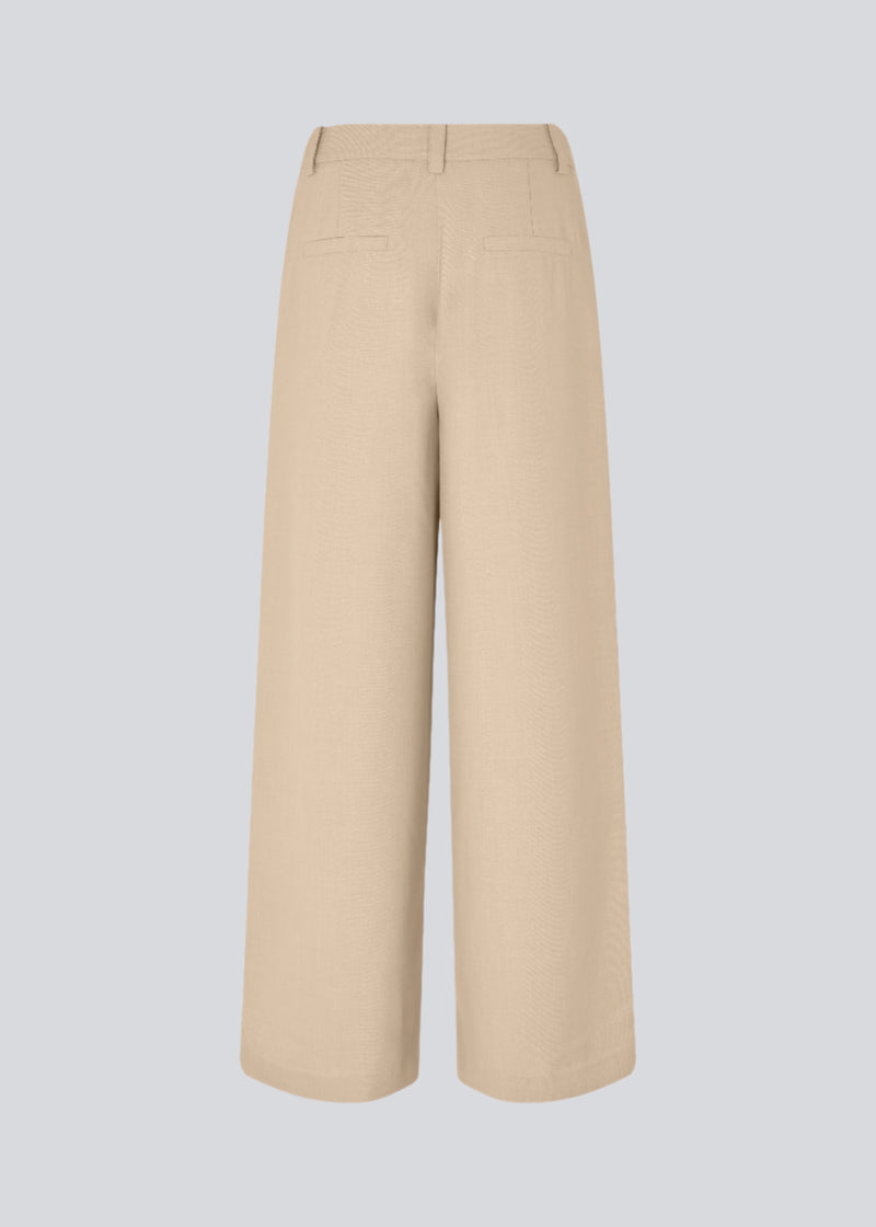 Lyse bukser med afslappet pasform. GaleMD 2 wide pants har almindelig talje med læg foran og brede, lange ben. Dekorative paspolerede lommer bagpå og sidelommer.

Opgrader din garderobe med GaleMD 2 Wide Pants fra Modström – en perfekt kombination af stil og komfort. Disse bukser i beige melange, har en løs pasform, høj talje og læg, der giver et elegant og flatterende look. Den fine basis farve, beige, gør dem lette at style til enhver anledning – fra afslappede hverdage til mere formelle outfits.
