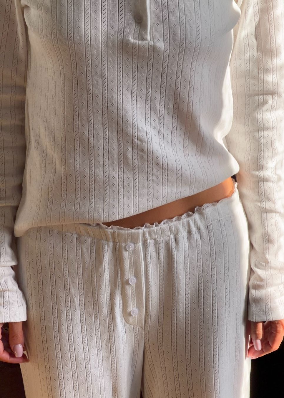 Ponitelle bukser. Josefinemd pants er feminine bukser i pointelle-bomuld med blondekant og diskret hulmønster. Blødt materiale og høj komfort gør dem perfekte til afslapning. Josefine Vogt (165 cm) og modellen (177 cm) har begge størrelse Small på.