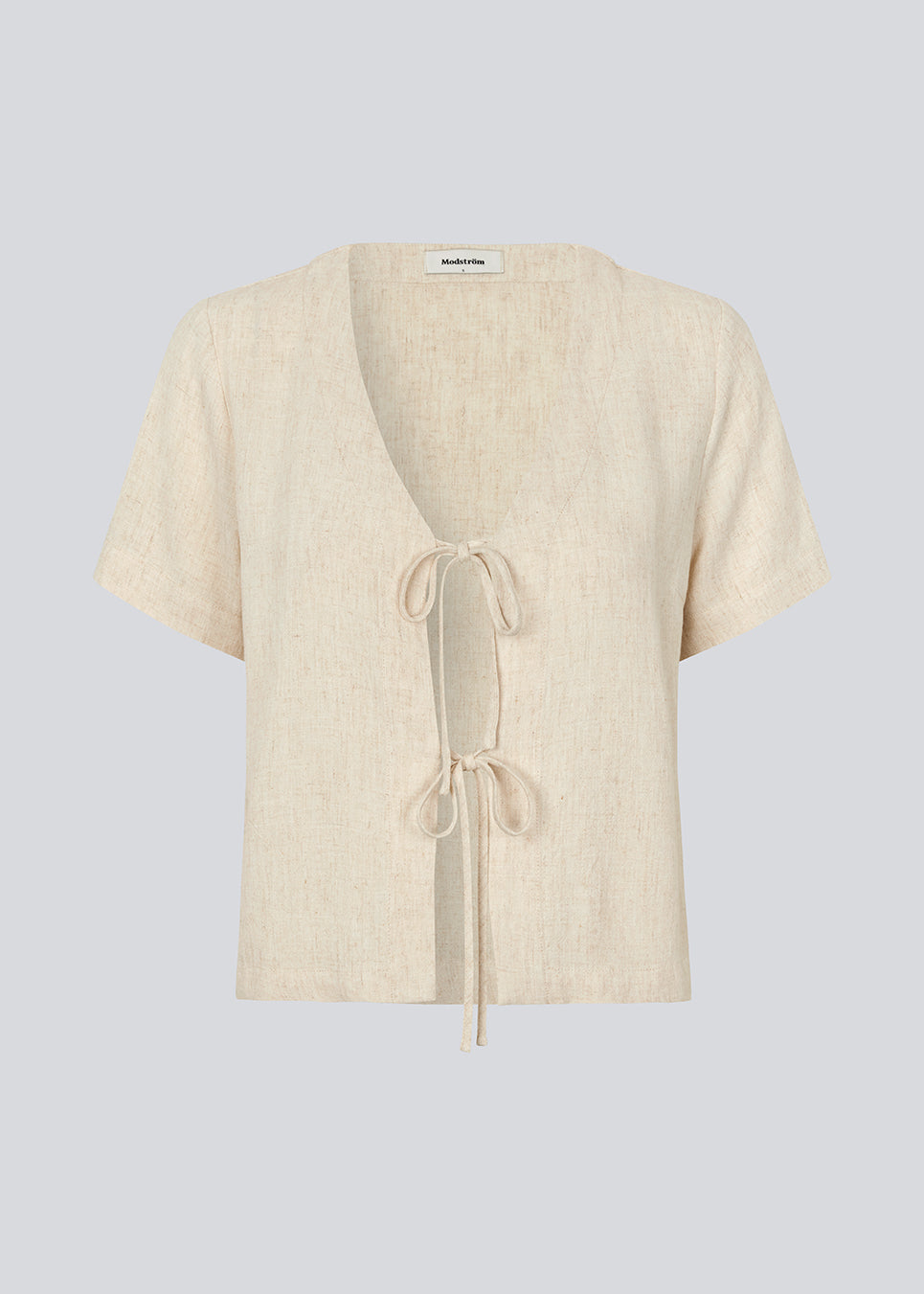 Bluse i hørblanding med korte ærmer. IrfanMD shirt har en dyb V-udskæring og lukkes med to bindebånd i foran. Modellen er 177 cm og har en størrelse S/36 på.