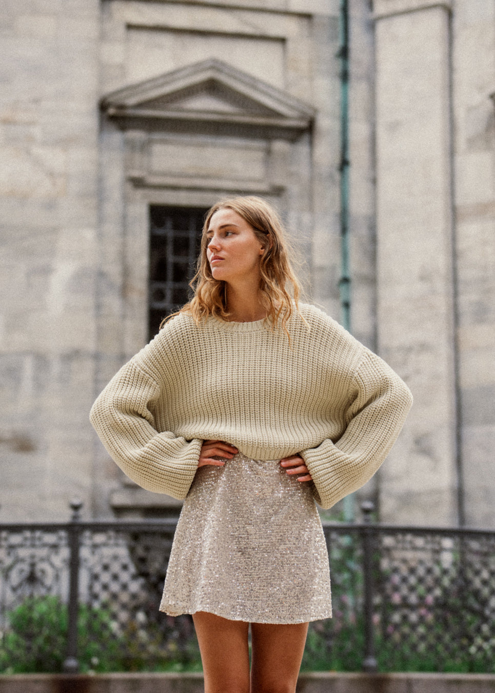 Grovstrikket trøje i beige i bomuldsstrik med bred, rund hals og let cropped længde. FlakaMD o-neck har en afslappet silhuet med ekstra lange ballonærmer. Modellen er 175 cm og har en størrelse S/36 på.