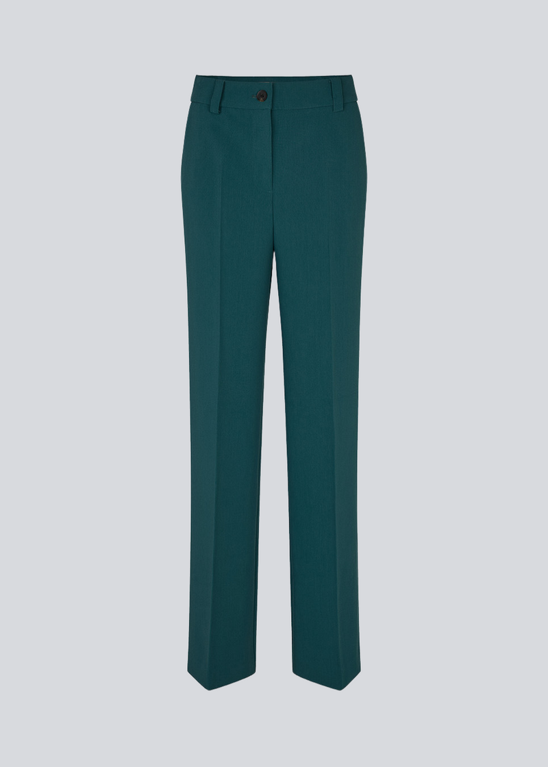 Mørkegrøn gale pants har et klassisk design. Buksen har lige, vide ben med pressefolder som skaber et elegant udtryk. Bukserne forlænges med 0,5 cm for hver størrelse.