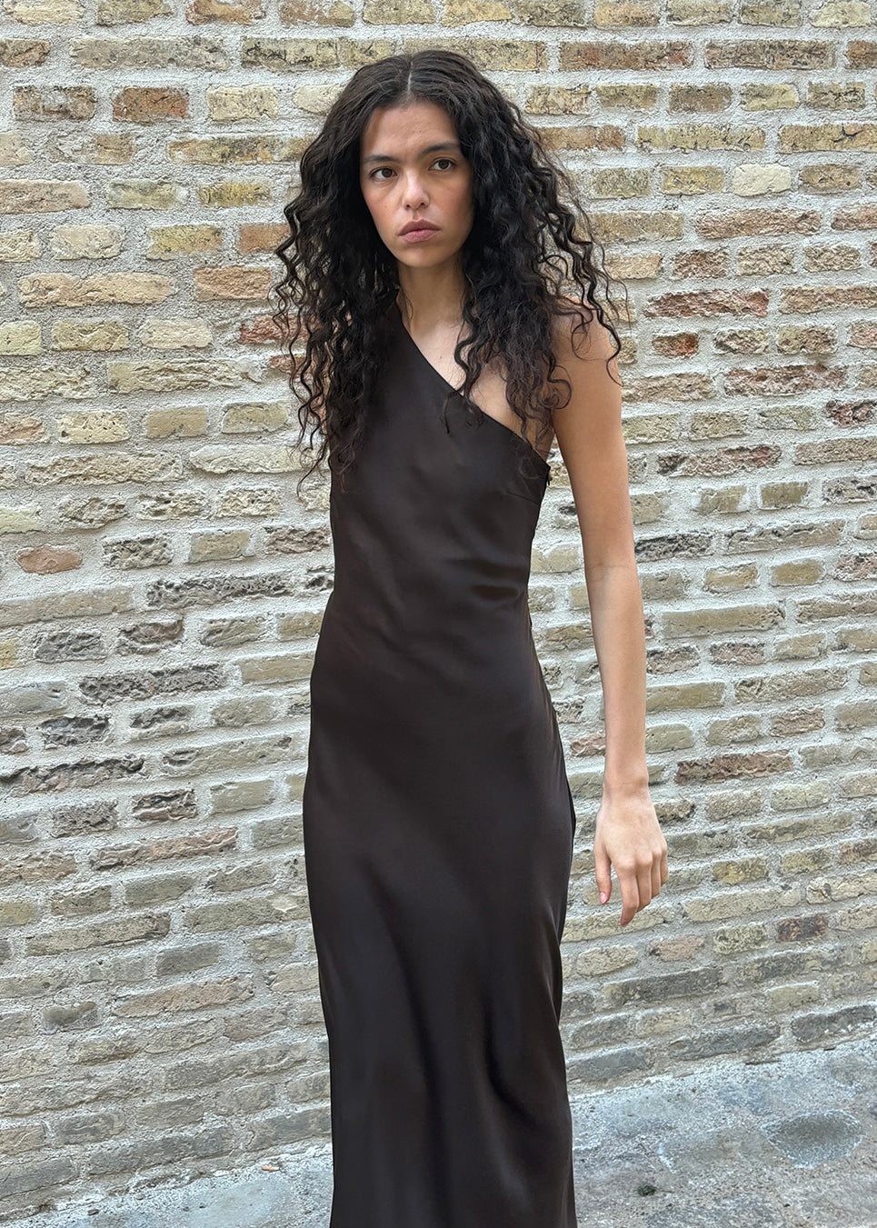 Vores populære Narcissamd dress er nu endelig kommet i en flot mørkebrun.
Mørkebrun lang one shoulder kjole i satin. NarcissaMD dress er en maxi dress med en åben ryg med smukke detaljer og en usynlig lynlås i siden.