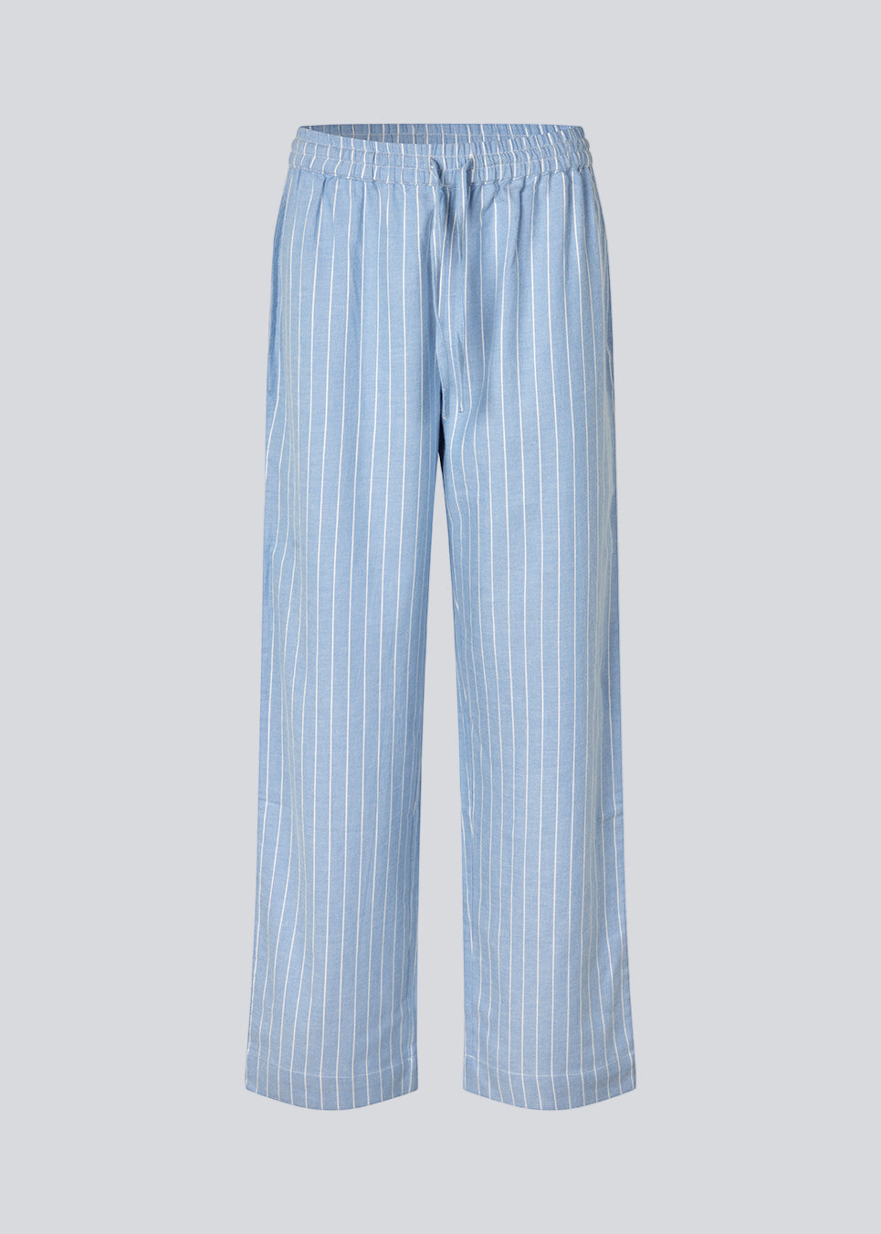 Blåt stribet pyjamas sæt i 100% bomuld. Pyjamas sælges samlet i to dele, skjorte og bukser. Josefinemd pyjamas har et klassisk fit med krave, knaplukning og snørre i bukserne. Sættet har en fin bølgekant og leveres med en matchende pose med logo. Det er ikke muligt at købe forskellige størrelser over- og underdel.&nbsp;