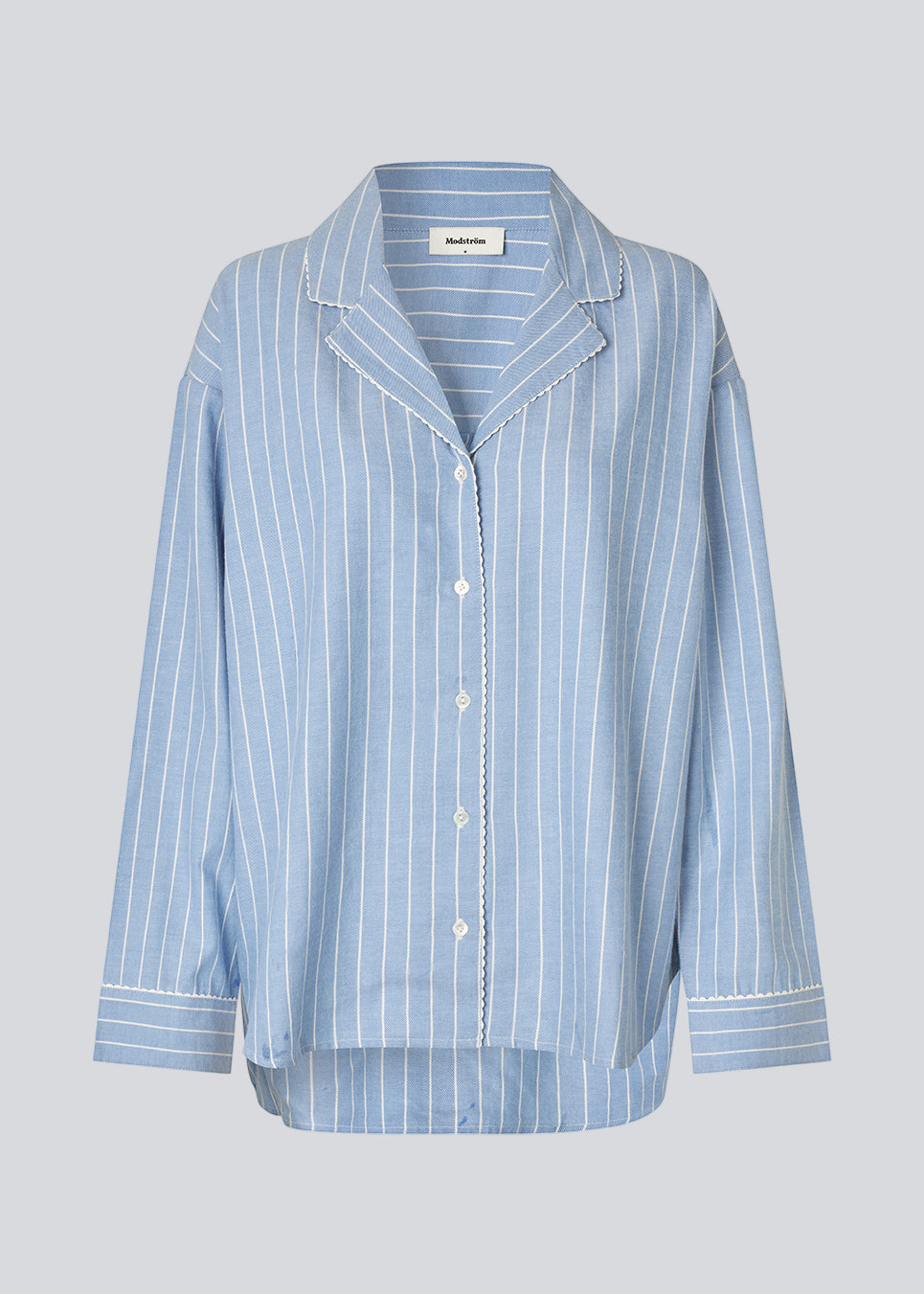 Blåt stribet pyjamas sæt i 100% bomuld. Pyjamas sælges samlet i to dele, skjorte og bukser. Josefinemd pyjamas har et klassisk fit med krave, knaplukning og snørre i bukserne. Sættet har en fin bølgekant og leveres med en matchende pose med logo. Det er ikke muligt at købe forskellige størrelser over- og underdel.&nbsp;