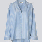 Blåt stribet pyjamas sæt i 100% bomuld. Pyjamas sælges samlet i to dele, skjorte og bukser. Josefinemd pyjamas har et klassisk fit med krave, knaplukning og snørre i bukserne. Sættet har en fin bølgekant og leveres med en matchende pose med logo. Det er ikke muligt at købe forskellige størrelser over- og underdel.&nbsp;