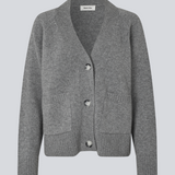 Grå strikket cardigan med V-udskæring i 100% uld. Petunamd cardigan har lange brede ærmer og to lommer fortil.&nbsp;