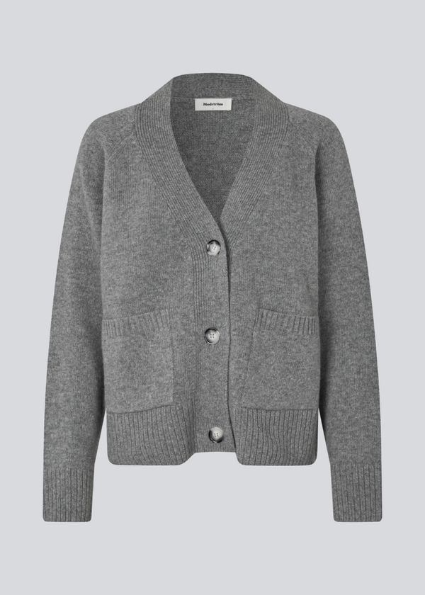 Grå strikket cardigan med V-udskæring i 100% uld. Petunamd cardigan har lange brede ærmer og to lommer fortil.&nbsp;