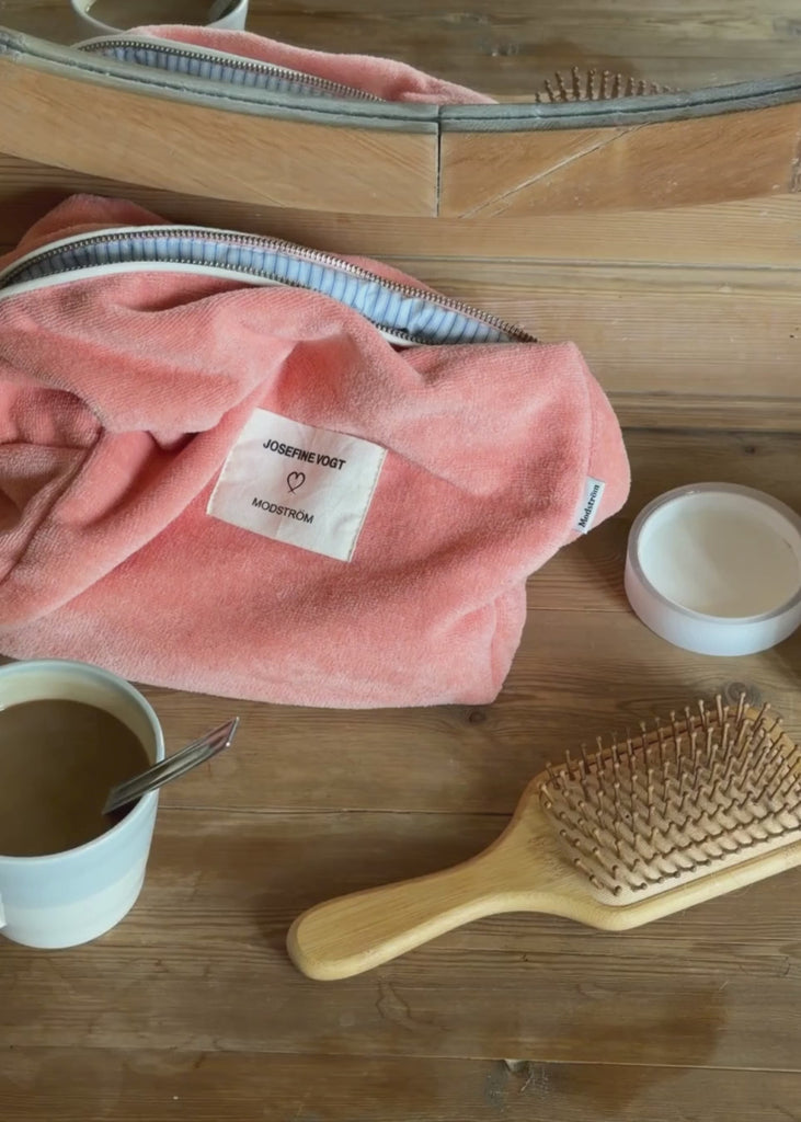 Lyserød toilettaske med påsyet logo. Josefinemd toiletry bag er en minimalistisk toilettaske i økologisk bomuld med lyseblåt for og lynlås. Praktisk og elegant – et must-have til rejsen eller badeværelset.
