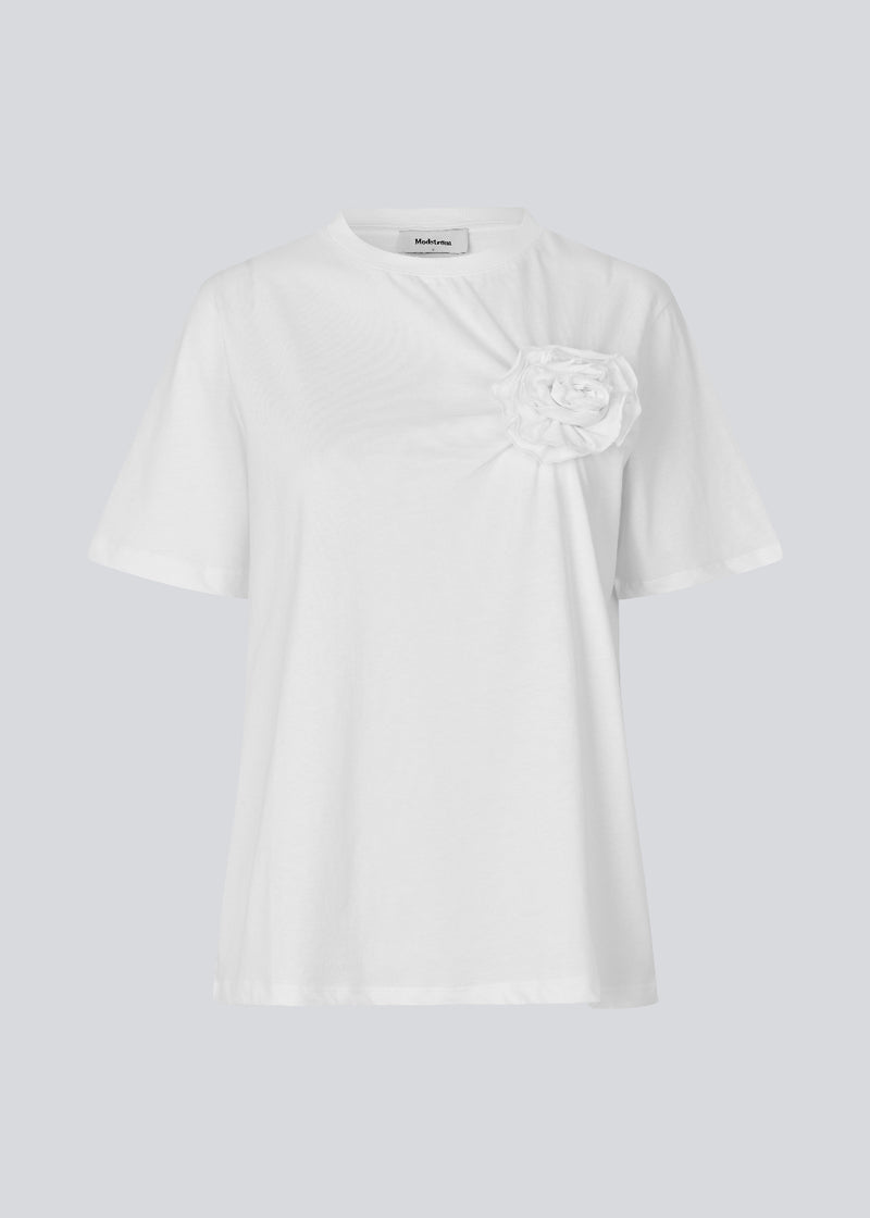 Kortærmet t-shirt med rose detalje på brystet. &nbsp;Priyamd t-shirt har en løs pasform og er fremstillet i 100% økologisk bomuld. Modellen er 175 cm og har en str S/36 &nbsp;på.
